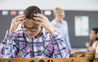 A male student frustrated in a classroom because of a lack of a personal education plan