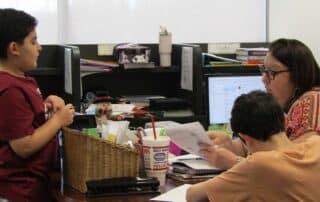 Tenney School students meeting with their teacher in a personalized learning environment.