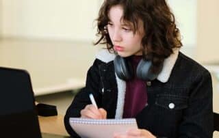 A student sitting at a desk at home attending an accredited online high school.