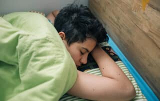 A student sleeping in showing why later school start times for teens is important.