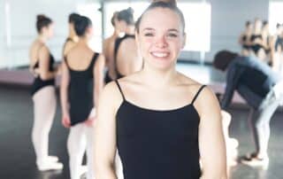 A teenage girl in a ballet dance class that is balancing school and her pursuits with online school.