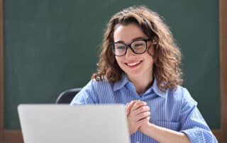 Young student smiling because she's in an online learning environment at home.
